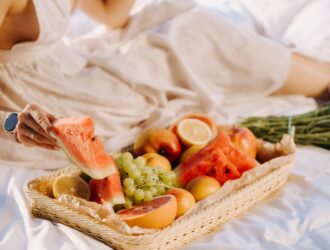 close-up of assorted fruits on a tray. The girl takes the fruit in her hands