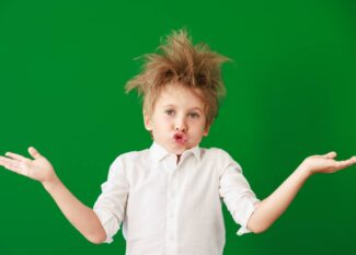 Surprised child against green chalkboard in class