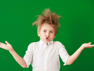 Surprised child against green chalkboard in class