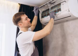 Plumber Repairing Air Conditioner Unit on Wall