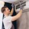 Plumber Repairing Air Conditioner Unit on Wall