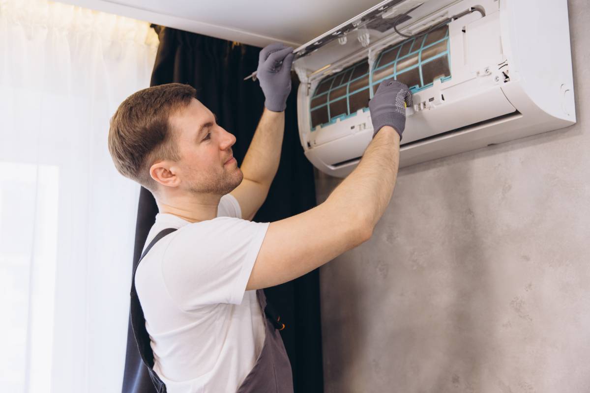Plumber Repairing Air Conditioner Unit on Wall