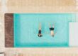 top view of couple lying in swimming pool and holding hands in Italy